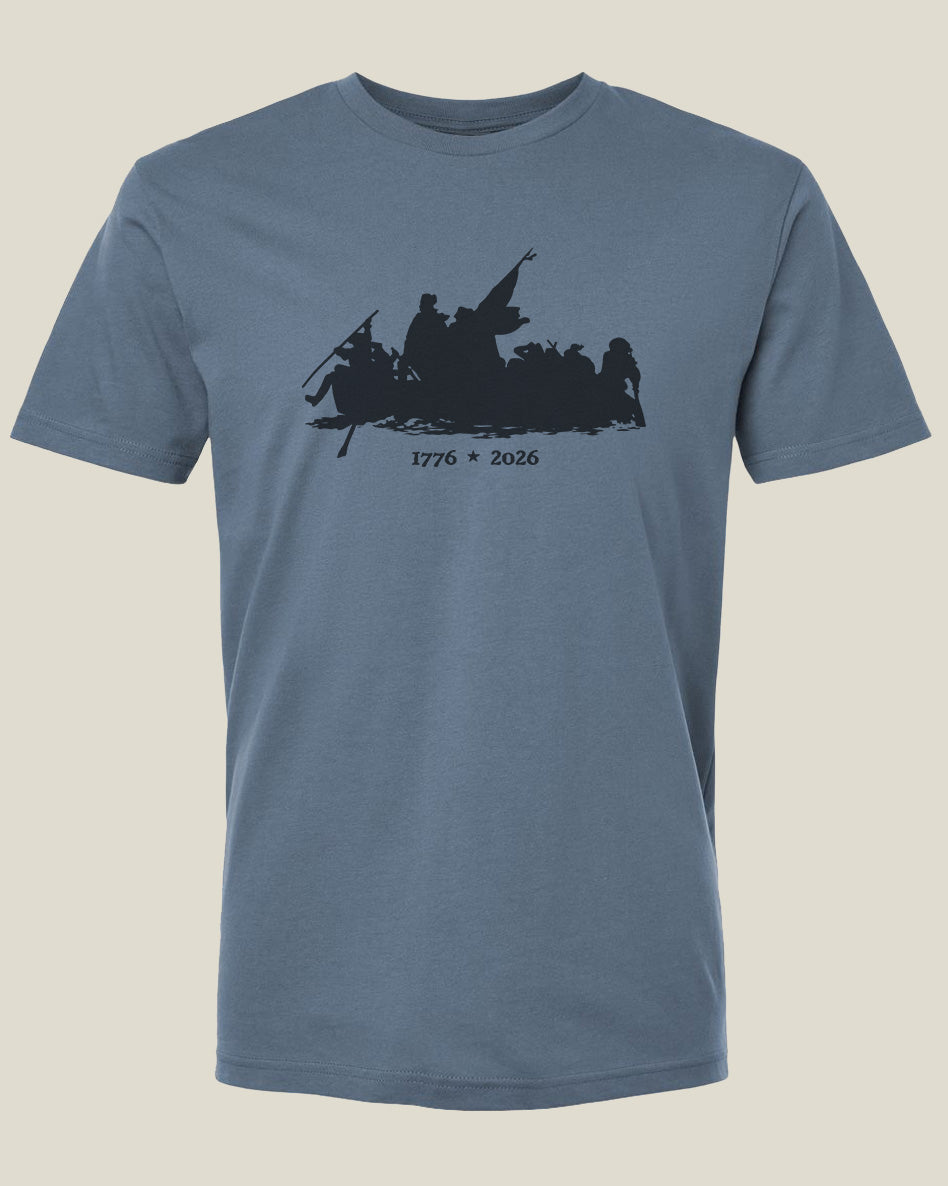 Steel blue cotton t-shirt with a graphic design depicting the Crossing of the Delaware with text 1776-2026
