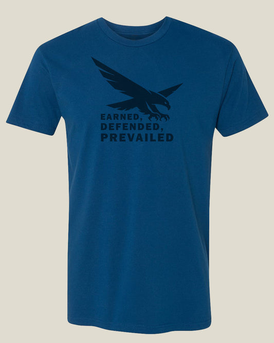 Blue t-shirt with an eagle graphic and text 'Earned, Defended, Prevailed'