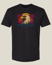 Black t-shirt with an 80's style eagle head graphic in front of a sunset with palm trees and retro blue grid