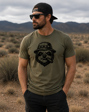man wearing the Slow is Smooth T-Shirt with a graphic of a sloth head wearing a boonie hat and smoking a cigar