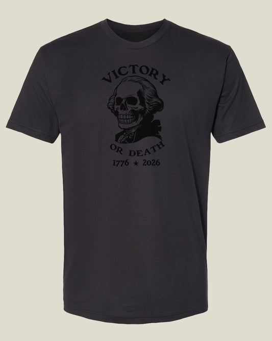 Graphite black cotton t-shirt with a graphic design featuring a George Washington skull and text 'Victory or Death' and '1776-2026'